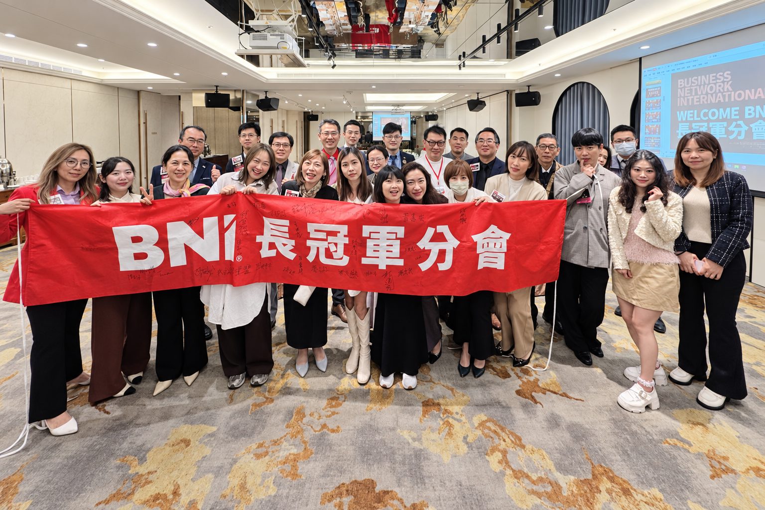 長冠軍分會夥伴在例會會場拿著分會布條的合照